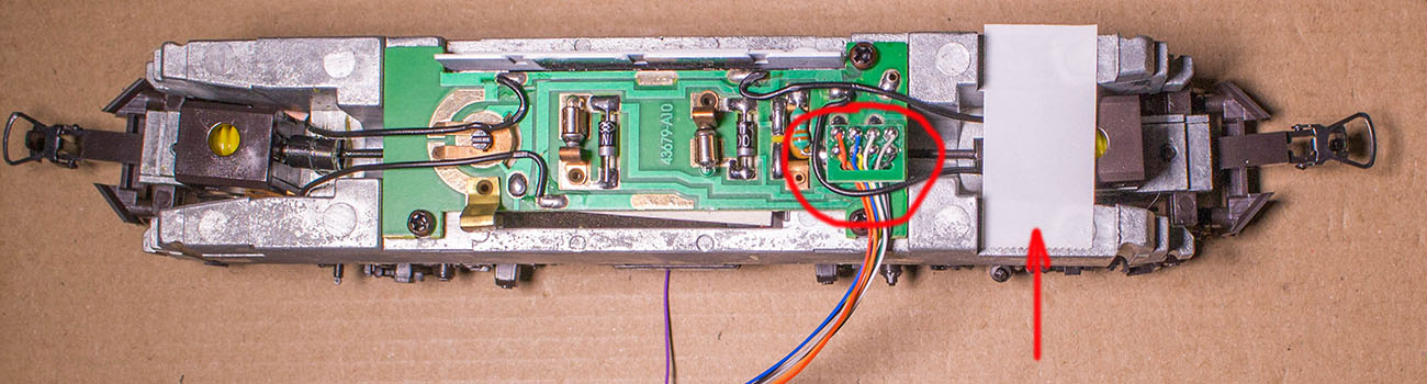 Dann den Stecker des Decoders einstecken (1) und auf die freie Stelle des Metallgewichtes ein Stück doppelseitiges Klebeband anbringen.